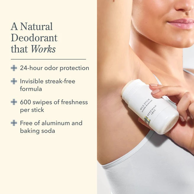 Deodorant stick being applied to a person's underarm with product details on the side.