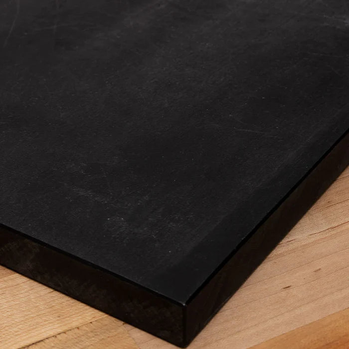 Black Tenryo High Contrast Cutting Board edge sitting on wooden table.
