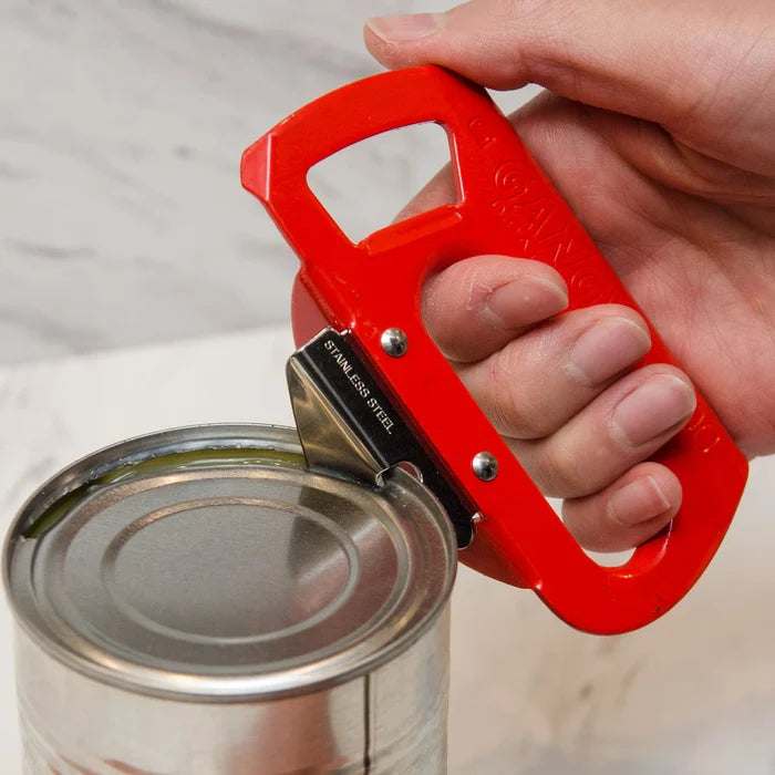 Hand held Japanese Red Gangy Can and bottle opener , opening silver canon grey table.