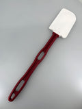 Red spatula with white head on a white background.