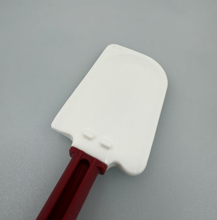 White spatula head with red handle on a white background.