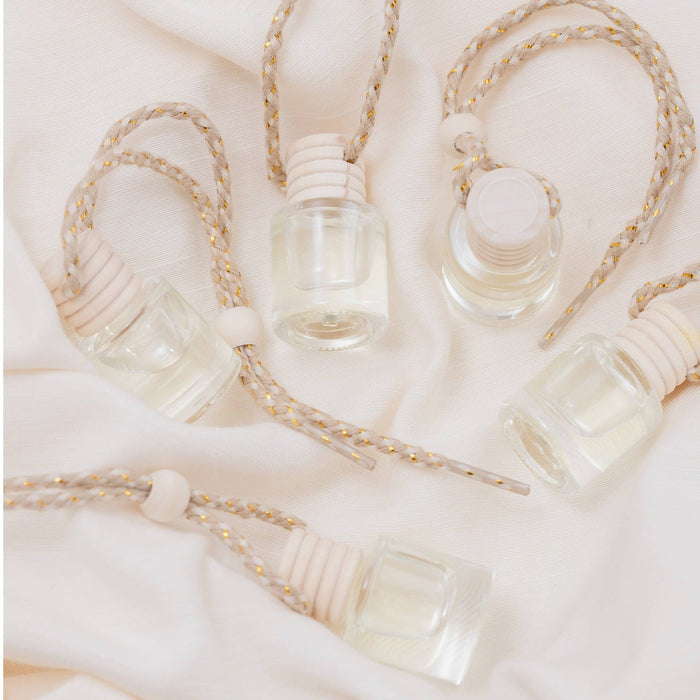 Rebellion Car Diffuser bottles with twine rope hangers on white fabric background