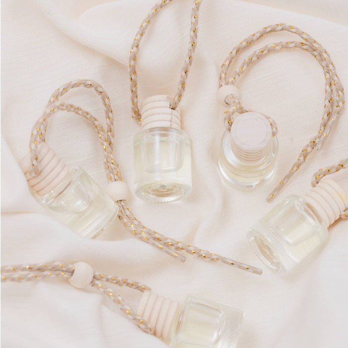 Satsuma car diffusers with twine rope hangers on white fabric background