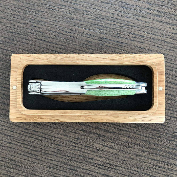 Folded corkscrew seen along its spine inside the oak gift box