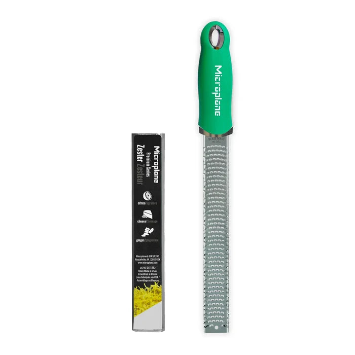 Green microplane zester with packaging on a white background