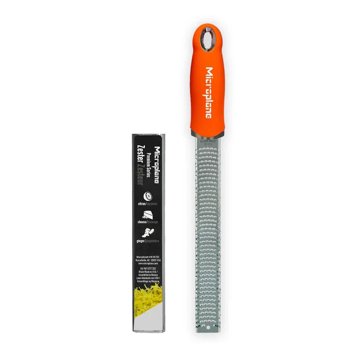 Orange Microplane zester with packaging on a white background
