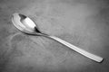 Silver Titanium spoon on a textured gray surface.