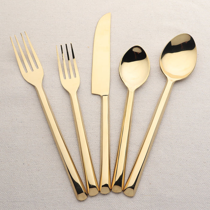 Set of gold cutlery including forks, knives, and spoons on a light gray background