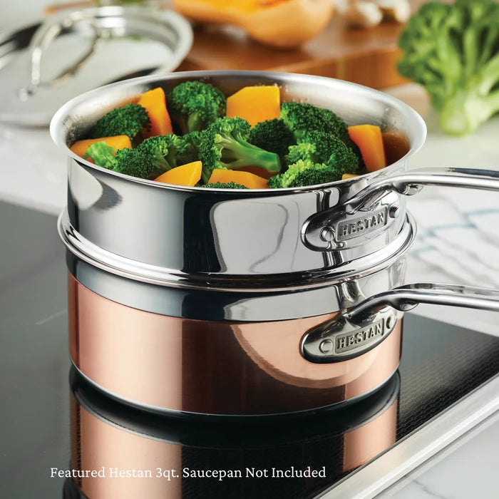 Stainless steel Steamer on a copper steamer, with marble kitchen top background with vegetables on a induction stovetop, featuring Hestan brand.