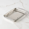 Stainless steel pan with a rack on a marble surface