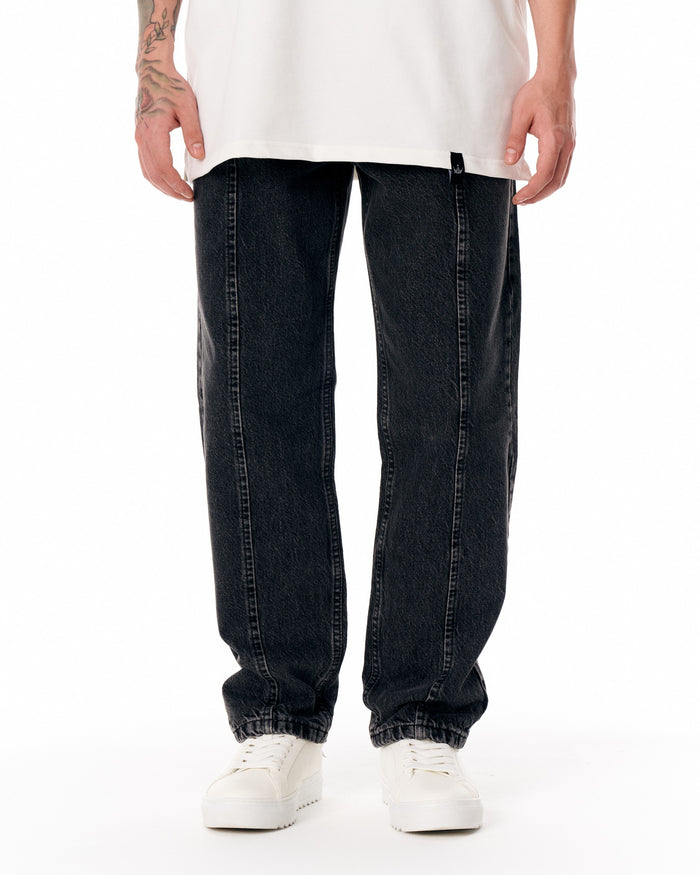 Martin Valen Urban Style washed black jeans, lower leg close-up showing elasticated hem and partially visible white sneakers